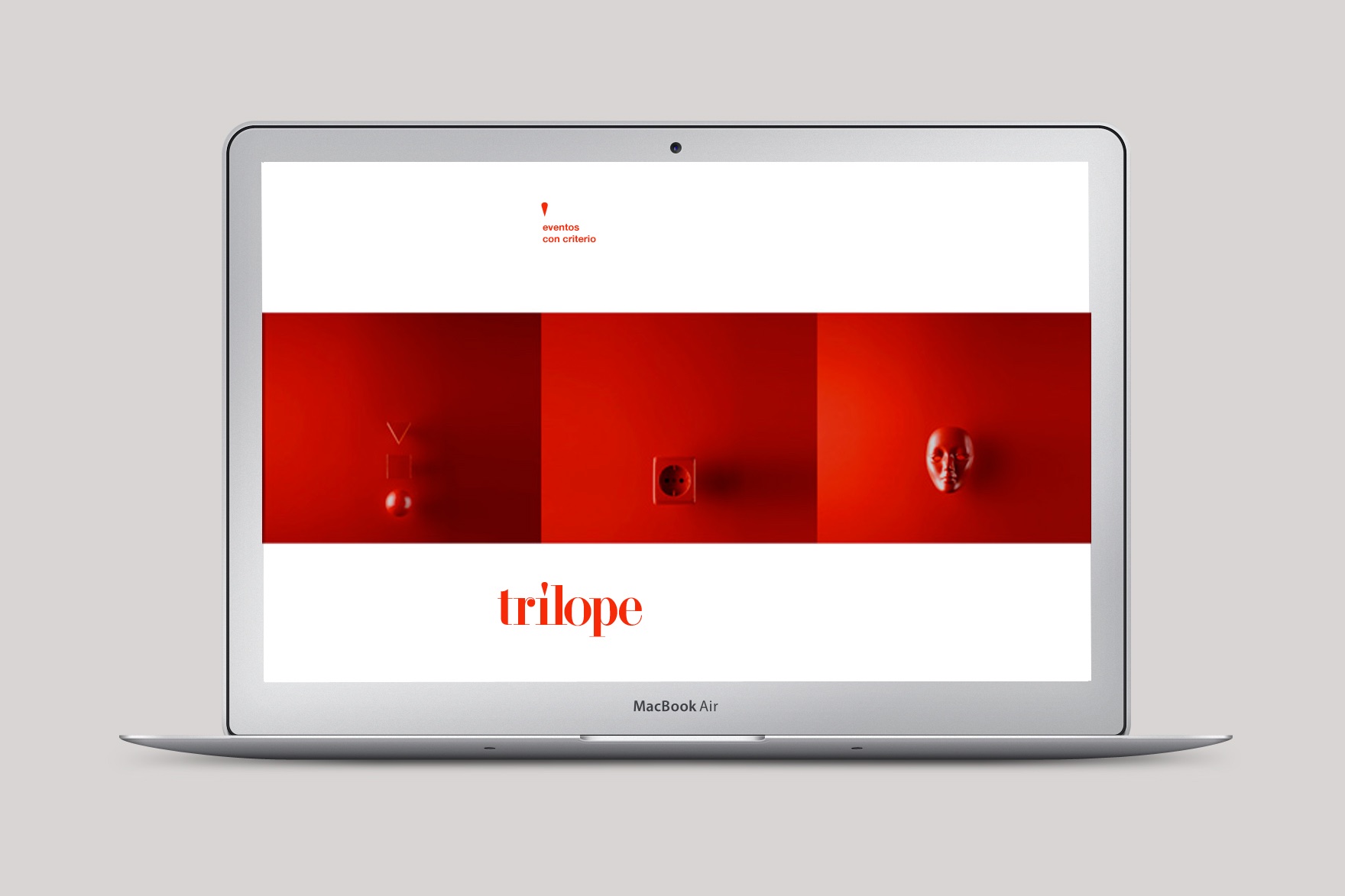 Maqueta para Macbook Air de la p&aacute;gina de INICIO de dise&ntilde;o minimalista de la web de TR&Iacute;LOPE. Incluye el logo rojo de Trilope y fotograf&iacute;as monocrom&aacute;ticas en rojo de una mascarilla, un interruptor el&eacute;ctrico y un globo. Dise&ntilde;ado por el estudio de branding y comunicaci&oacute;n esiete y programado por sevenap.