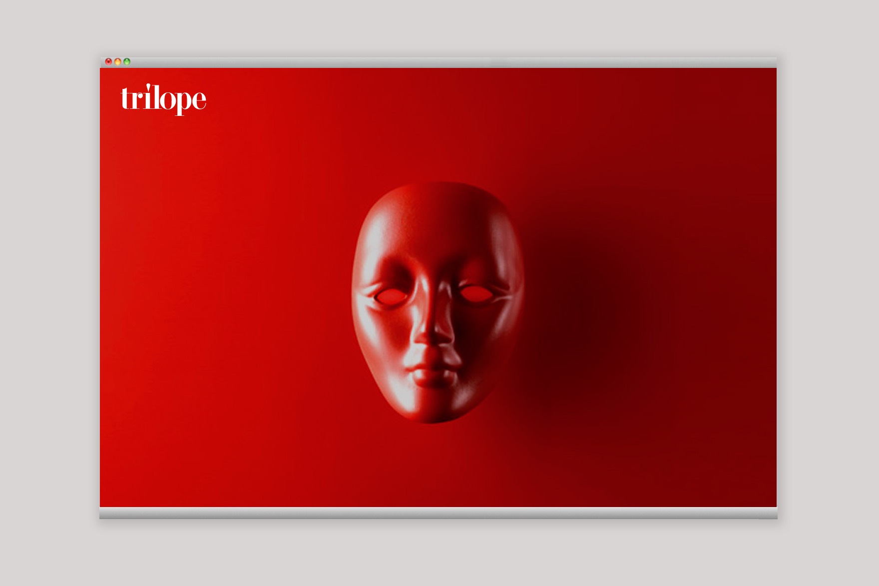 Imagen de una mascarilla roja sobre un fondo rojo de la web de TR&Iacute;LOP. Web dise&ntilde;ada por el estudio de branding y comunicaci&oacute;n esiete y programada por sevenap.