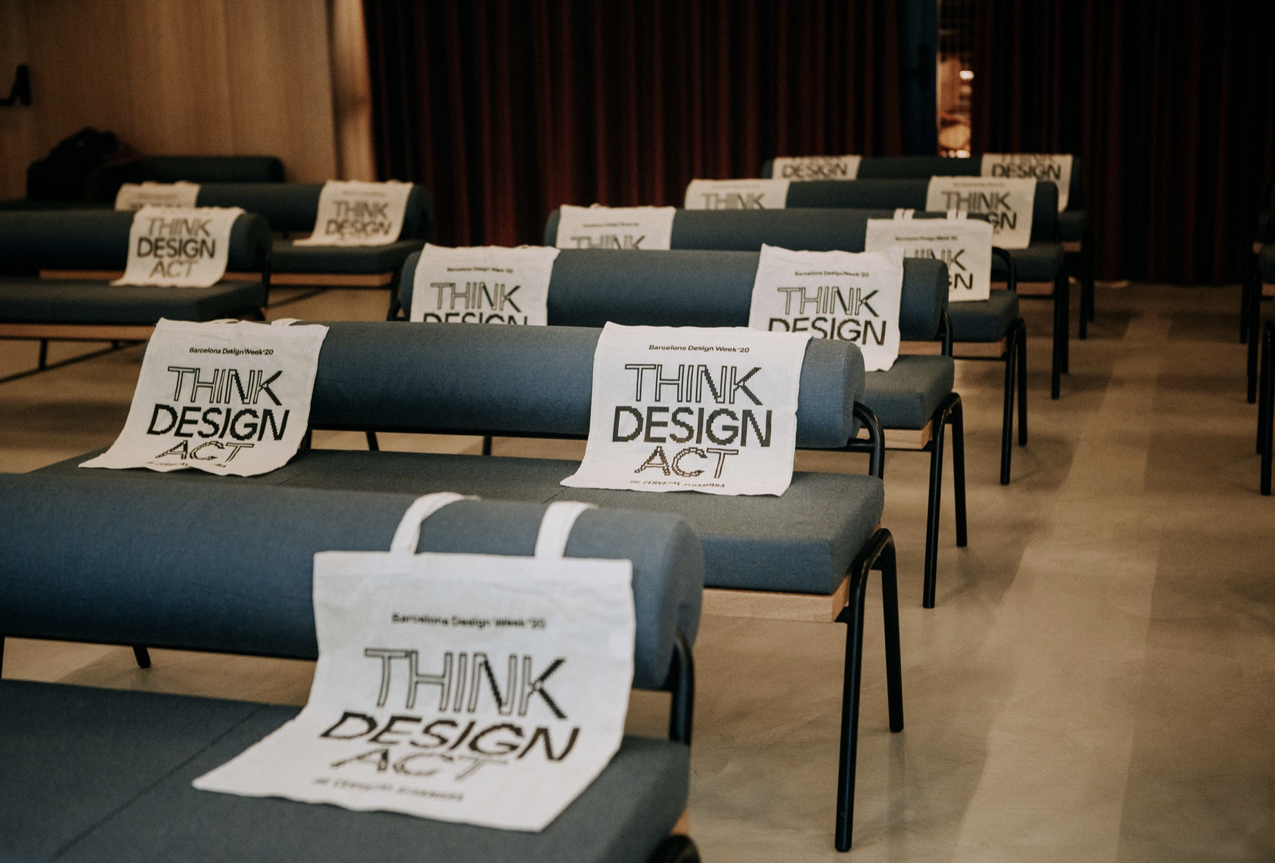 Cartel innovador &ldquo;districts disseny, Think design act&rdquo;, donde se recorta el &aacute;rea de la imagen para que se pueda ver la instalaci&oacute;n art&iacute;stica que hay detr&aacute;s. Dise&ntilde;ado por el estudio de branding y comunicaci&oacute;n Esiete.