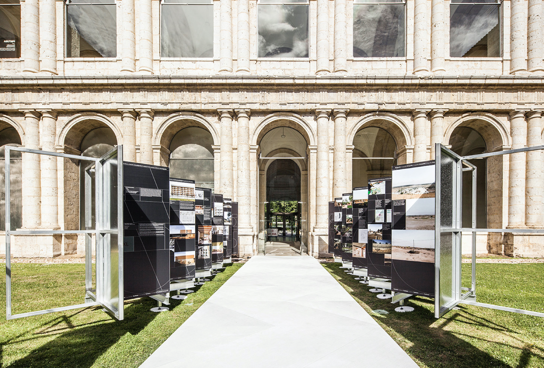 <span><span>Imatge de l'exposici&oacute; XV Biennal Espanyola d'Arquitectura i Urbanisme amb dues s&egrave;ries de cartells una a cada costat en forma de ziga-zaga. Dissenyat per l'estudi esiete de branding i comunicaci&oacute;.</span></span>