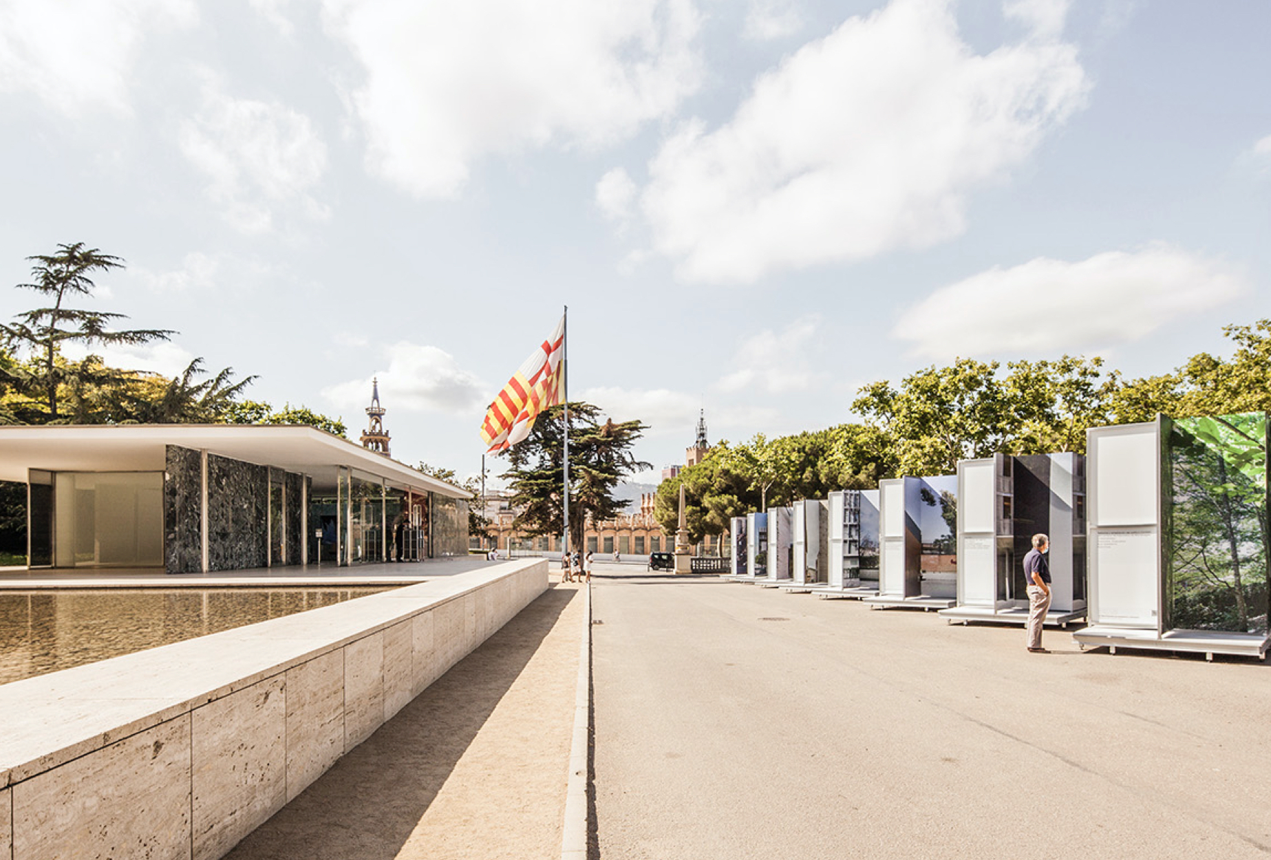 <span><span>Imatge del XV Biennal Espanyola d'Arquitectura i Urbanisme, on podem veure un home interactuant amb unes s&egrave;ries de cartells en ziga-zaga els quals mostren diferents edificis i paisatges naturals. Dissenyat per l'estudi esiete de branding i comunicaci&oacute;.</span></span>