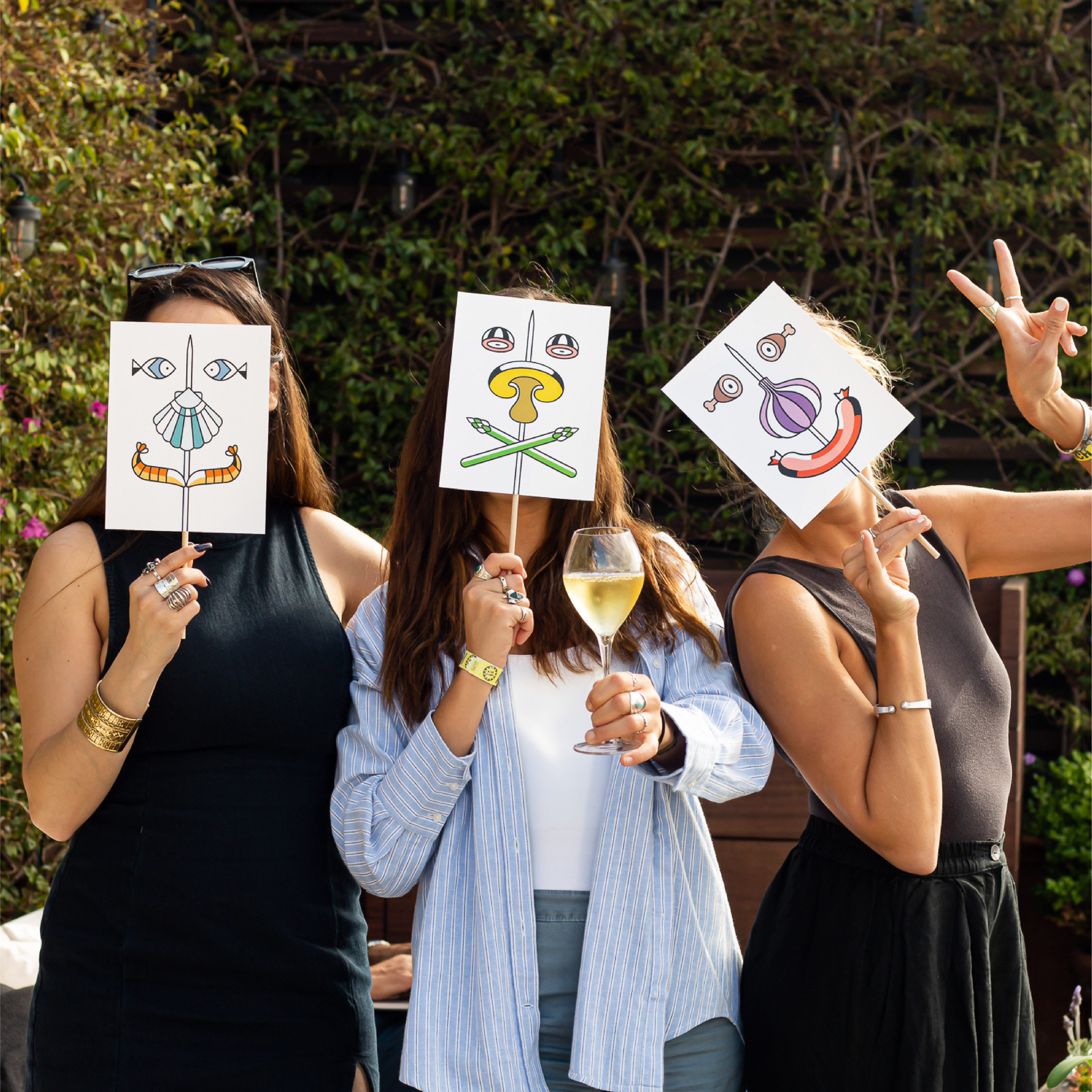 <span><span>Foto de tres chicas, con tres carteles en frente de la cara con la gr&aacute;fica del HOTEL TAPA TOUR 2023, donde aparecen diferentes elementos de tapas formando una cara. Animaci&oacute;n repetitiva donde a partir de un pincho, </span><span>y</span><span> elementos que encontramos en platos de tapas, se van formando caras. Dise&ntilde;ado por el estudio esiete de branding y comunicaci&oacute;n.</span></span>