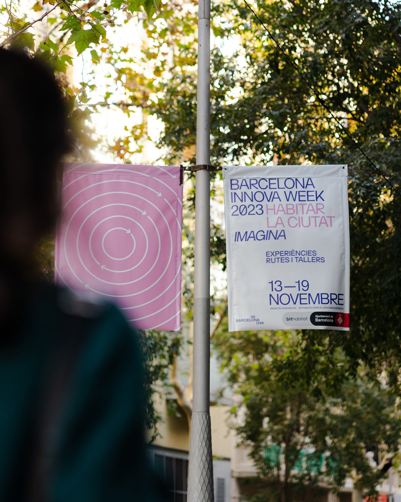 Carteles de la campa&ntilde;a gr&aacute;fica BARCELONA INNOVA&nbsp;WEEK&nbsp;2023 de color rosa colgadas en una farola de BARCELONA. Dise&ntilde;ado por el estudio&nbsp;esiete&nbsp;de branding y comunicaci&oacute;n.