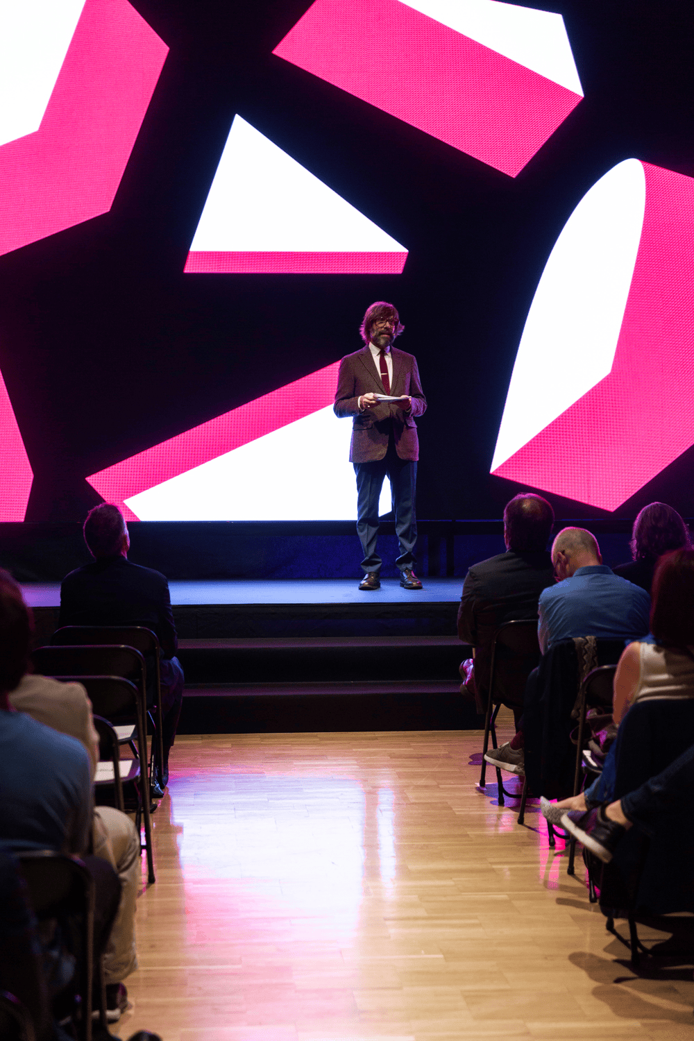 Presentaci&oacute;n en p&uacute;blico del redise&ntilde;o de la identidad visual de los Premios FAD de Arquitectura e Interiorismo de 2024. Imagen en pantalla digital de la nueva identidad con formas geom&eacute;tricas de color blanco y rosa ilustradas en 3D.