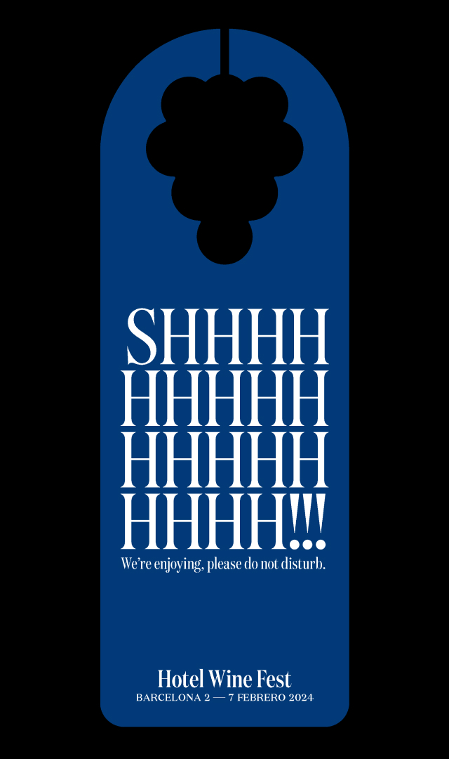 Un colgador de puerta de color azul sobre un fondo negro, en el que pone Shhh!!! We&rsquo;re enjoying, please do not disturb, escrito con una tipograf&iacute;a serif moderna y con un agujero en el asa representando la silueta de un ramo de uvas. En la parte inferior, el logotipo tipogr&aacute;fico de Hotel Wine Fest y la fecha: Barcelona 2 &mdash; 7 Febrero 2024.