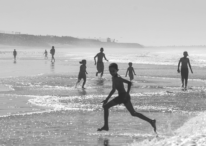 Fotograf&iacute;a en blanco y negro de ni&ntilde;os peque&ntilde;os jugando en la playa.
