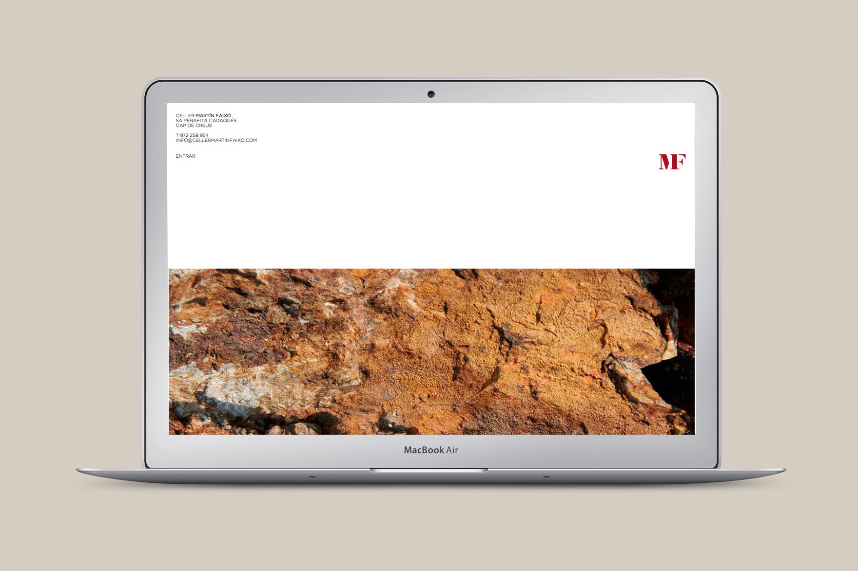 Disseny de la landing page del web de CELLER MART&Iacute;N FAIX&Oacute;. Inclou el logotip vermell de MF, un disseny minimalista amb molt espai en blanc i una textura fotogr&agrave;fica de roques de muntanya. Web dissenyada per l'estudi de comunicaci&oacute; i marca Esiete i programada per sevenap.